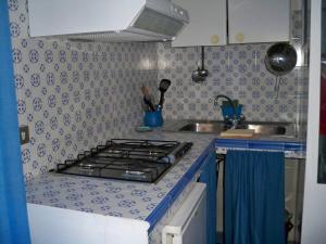una cucina con piano cottura e lavandino di L'Isolana Case Vacanza Palma 1 a Ponza