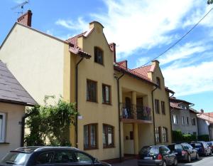 a yellow building with cars parked in front of it at Mini apartament in Łańcut