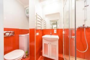 キーウにあるMalinovskogo Street Area Apartmets (119)のオレンジ色の壁のバスルーム(トイレ、シャワー付)