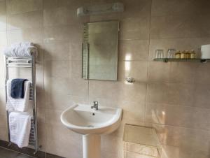 a bathroom with a sink and a mirror at The Pipers Rest in Doolin