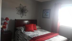a bedroom with a bed with red pillows on it at Aggie's B&B in Bonavista