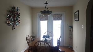 a dining room with a table and chairs and a chandelier at Aggie's B&B in Bonavista