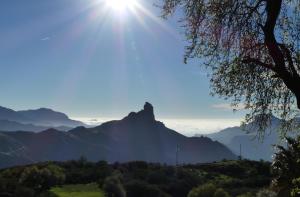 uma vista para uma montanha com o sol no céu em Mountain Hostel Finca La Isa em Tejeda
