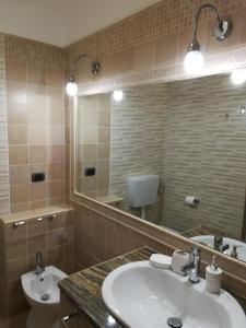 a bathroom with a sink and a toilet and a mirror at La Collina Capo d'Orlando in Capo dʼOrlando +62 photos