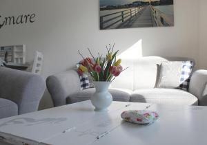 Un jarrón de flores sobre una mesa en una sala de estar. en Ostseehaus Oe, en Sierksdorf 20 fotos más