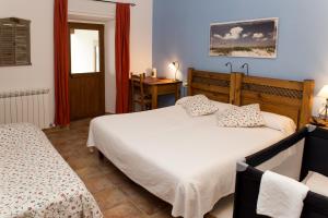 a bedroom with two beds and a table and a window at Casa Rural Flor de Vida - B&B in Lizaso
