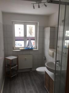 une salle de bain avec un lavabo et des toilettes et une fenêtre dans l'établissement Seepferdchen, à Stralsund