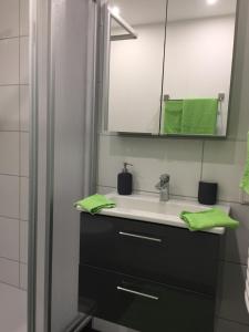 y baño con lavabo, espejo y toallas verdes. en Apartment Ferienwohnung en Sulzbach