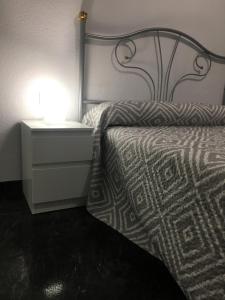 バレンシアにあるCarrer de María Montessoriのベッドルーム1室(ベッド1台、ランプ付きのナイトスタンド付)