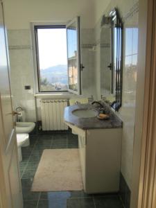 Fratta TodinaにあるLa Casa della Magnoliaのバスルーム(洗面台、トイレ付)、窓が備わります。
