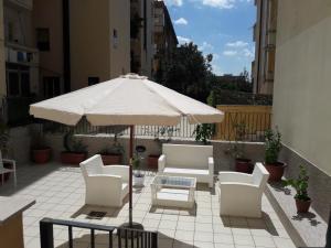 patio con tavolo, sedie e ombrellone di Sweet Home La Ville a Caserta
