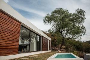 a house with a swimming pool next to a window at Vistasol in Río Ceballos