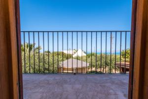 a gate with a view of a beach from a balcony at B&B Le Dune - Self Check in in Lascari