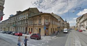 an old building on a city street with cars parked at Arkadija - Filatova in Lviv