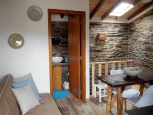 a living room with a table and a stone wall at Casa da Alta in Coja