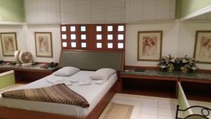 Schlafzimmer mit einem Bett, einem Schreibtisch und einem Fenster in der Unterkunft Heru's Motel in Poços de Caldas
