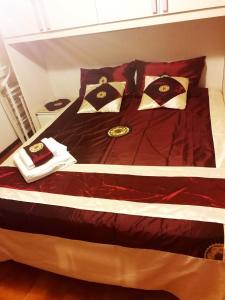 a bed with red sheets and gold pillows on it at Casa Elia in Venice
