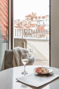 a table with a glass of wine and a plate of food at The Lumiares Hotel & Spa - Small Luxury Hotels Of The World in Lisbon