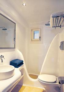 a white bathroom with a sink and a toilet at Zephyros in Paraga