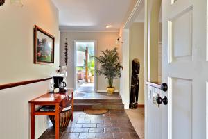 a hallway with a wooden table and a door at Orchid Tree B&B in Hilo