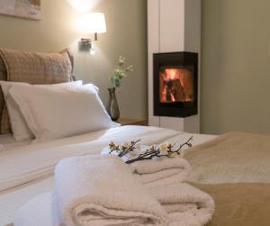 a bedroom with a bed with towels and a fireplace at Edem Luxury Apartments in Nea Peramos