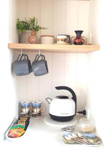 a kitchen counter with a toaster and dishes on a shelf at Alkira in Leongatha