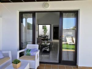 a living room with sliding glass doors and chairs at Casita La Concha in Playa Honda