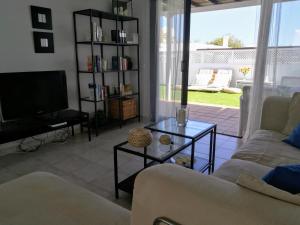 a living room with a couch and a tv at Casita La Concha in Playa Honda