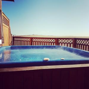 a hot tub on a deck with the ocean in the background at Guesthouse Didi in Flagbjarnarholt