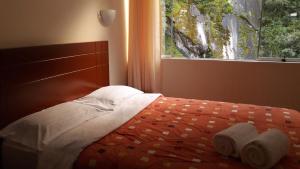 a bedroom with a bed with towels on it and a window at Casa Machu Picchu Hostel in Machu Picchu +92 photos