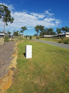 a white box sitting on the grass next to a road at Adwaga Lodge in Tamborine