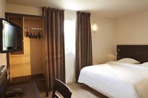 a hotel room with a bed and a television at Escale Oceania Aix-en-Provence in Aix-en-Provence