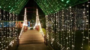 a boardwalk covered in christmas lights at night at Baanraisooksangchan in Kaeng Krachan