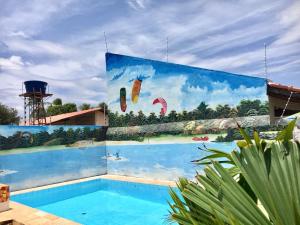 a mural on the side of a building with a swimming pool at Hotel Hostel Caçari in Boa Vista