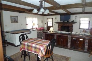 sala de estar con mesa y cocina en Old Field House en North Conway