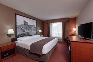 a hotel room with a bed and a flat screen tv at Super 8 by Wyndham St Johns in St. John's