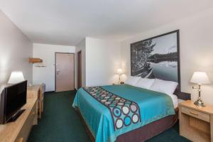 Habitación de hotel con cama y TV de pantalla plana. en Super 8 by Wyndham Moose Jaw SK, en Moose Jaw