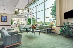 a living room with couches and a tv and windows at Days Inn by Wyndham Arlington/Washington DC in Arlington