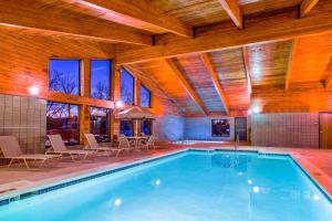 a swimming pool in a house with a wooden ceiling at AmericInn by Wyndham Medora in Medora