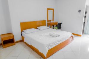 a bedroom with a large bed with white sheets at Chonnatee Residence in Chum Phae
