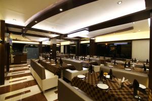 a restaurant with tables and chairs in a room at Atithi The Hotel in Ahmedabad