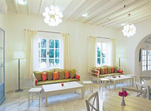 a living room with couches and tables and windows at Zephyros in Paraga