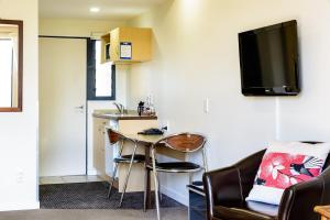 a living room with a table and a kitchen at Nautilus Lodge Motel in Motueka
