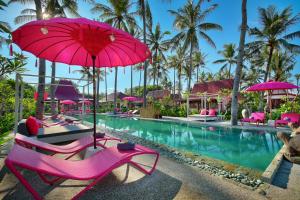 a resort with pink chairs and a pool with pink umbrellas at PinkCoco Gili Air in Gili Islands