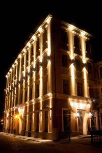 een verlicht gebouw met 's nachts verlichting bij Hotel Justus in Rīga