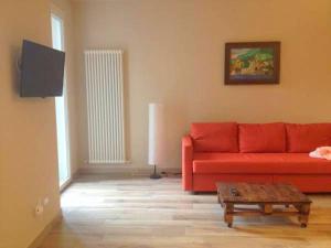 Sala de estar con sofá rojo y mesa de centro en La Giazzera, en Dervio