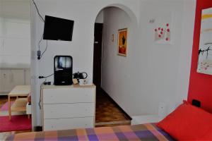 - une chambre avec un lit et une commode avec une télévision dans l'établissement Bed & Breakfast il Bolentino Varenna, à Varenna