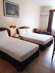 關丹的住宿－馬來西亞關丹斯里酒店，酒店客房带两张床和一张桌子以及椅子。