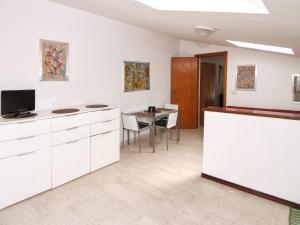 ミラッツォにあるIl Covo sul portoの白いキャビネットとテーブル(テレビ付)が備わるアパートメントです。