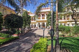 ein Gebäude mit einer Palme und zwei Parkuhren in der Unterkunft Alsisar Haveli - Heritage Hotel in Jaipur